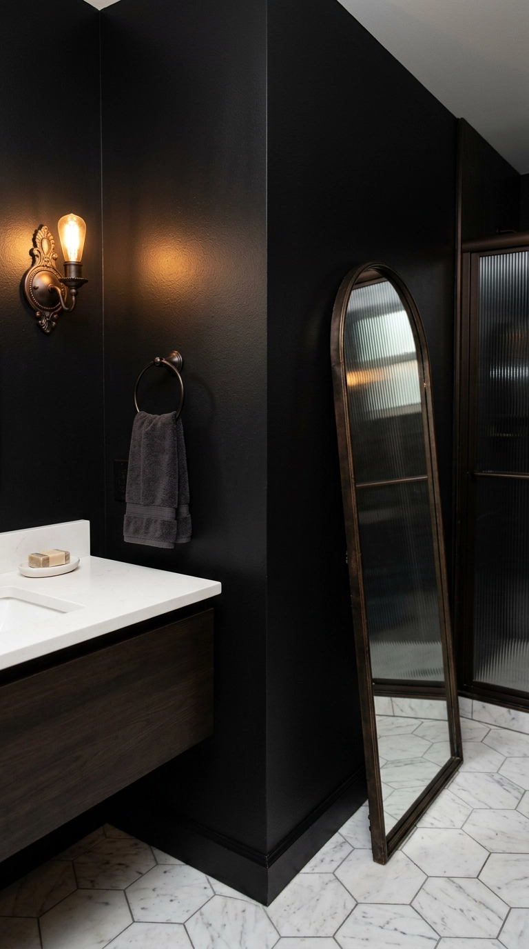 Satin black walls with an arched floor mirror and bronze fixtures in a moody gothic bathroom